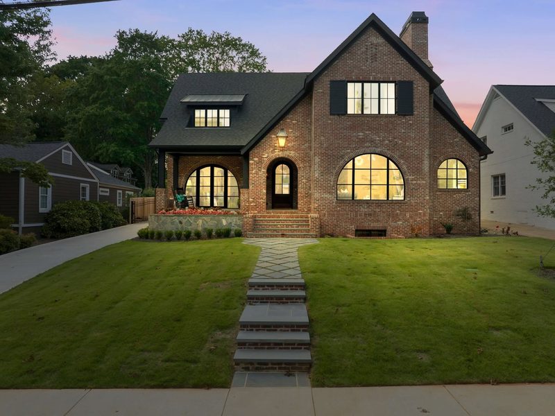 Black arched windows on a brick home at dusk